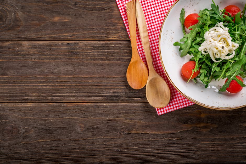 A vibrant arugula salad with tomatoes and cheese on a rustic wooden table, perfect for healthy dining.