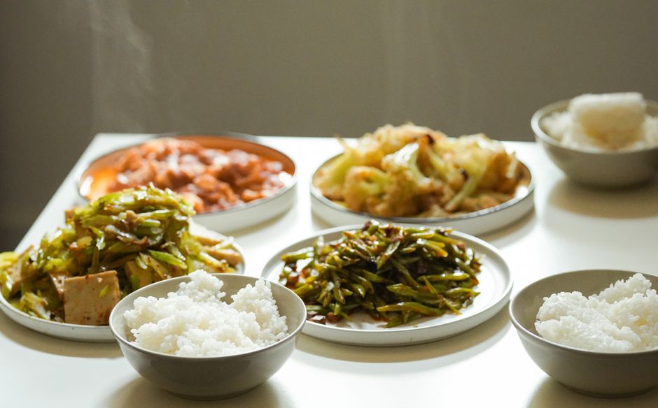 A flavorful spread of Asian dishes including rice, vegetables, and meat, perfect for a traditional meal.
