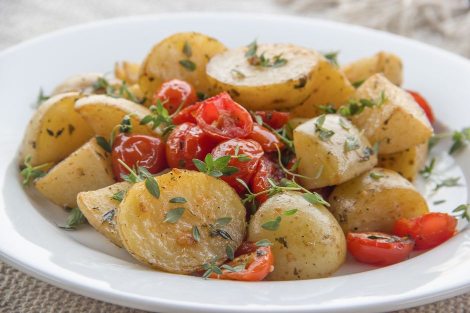 Savor the taste of herb-infused roasted potatoes paired with juicy cherry tomatoes for a delightful meal.