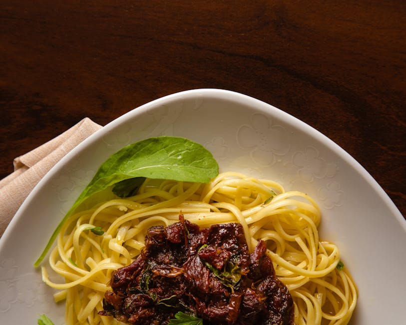 A plate of spaghetti with beef and basil ready for a delicious meal.